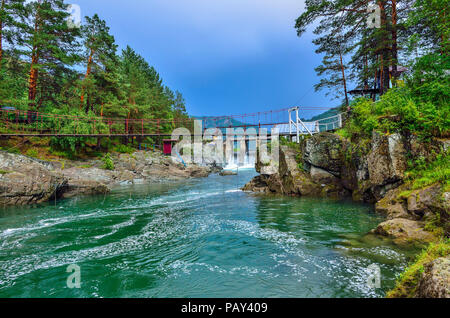 Schönen Sommer Bergwelt auf tschemal Fluss, Altai Gebirge, Russland Brücke zwischen felsigen Ufern, Damm der alten Wasserkraftwerk, über Stockfoto