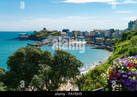 Den hübschen Küstenort Tenby, Pembrokeshire, Wales, UK sieht unter einem blauen Sommerhimmel. Bunte Häuser umgeben den Hafen bei Flut. Stockfoto