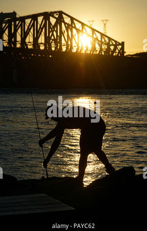 Leute Angeln vom Parc de la Marina de La Chaudière, St-Romuald, Quebec, mit dem St Lawrence Rier in Pont du Quebec hinter Stockfoto