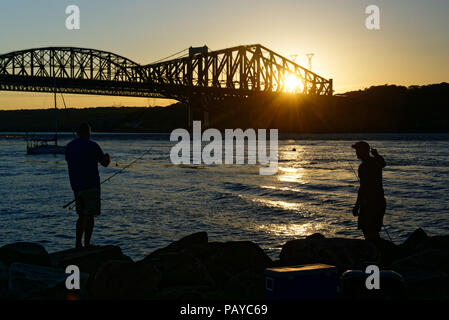 Leute Angeln vom Parc de la Marina de La Chaudière, St-Romuald, Quebec, mit dem St Lawrence Rier in Pont du Quebec hinter Stockfoto