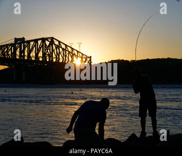 Leute Angeln vom Parc de la Marina de La Chaudière, St-Romuald, Quebec, mit dem St Lawrence Rier in Pont du Quebec hinter Stockfoto