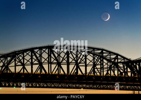 Der Pont du Quebec und der St. Lawrence River in der Dämmerung vom Parc de la Marina de La Chaudière, St-Romuald mit einer sichelförmigen Mond mit erdschein hinter Stockfoto