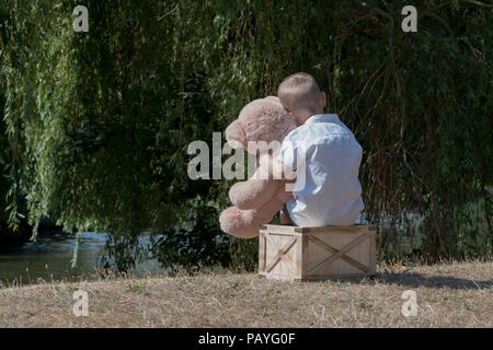 Kind mit Plüsch Spielzeug in Park Stockfoto