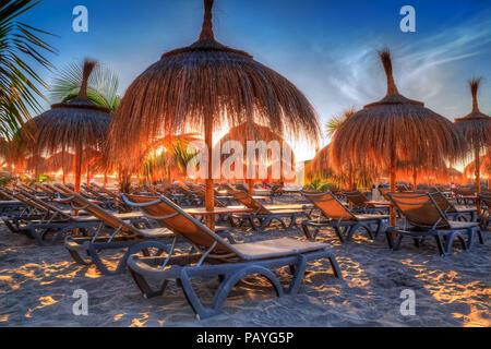 Sonnenliegen und Sonnenschirme im Abendlicht am Strand von Torviscas Teneriffa, Kanarische Insel im Sommer Urlaub, Spanien Stockfoto