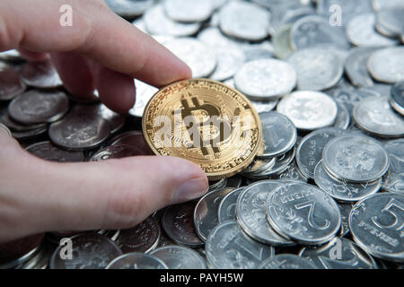 Goldmünze bitcoin in der Hand auf russische Rubel Münzen Nahaufnahme Stockfoto