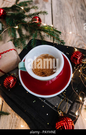 Lecker Espresso am Morgen Kaffee in eine grüne und eine rote Tasse Untertasse, auf der rustikalen Holztisch mit festlichen (Weihnachten, Silvester) Dekorationen, Geschenke Stockfoto