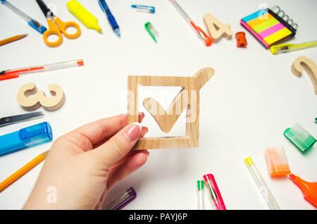 Wahl des Präsidenten der Klasse und der Schule. Wahl Kontrollkästchen und Schule Zubehör auf einem Schreibtisch auf einem weißen Hintergrund. Bildung. Schreibwaren, w Stockfoto