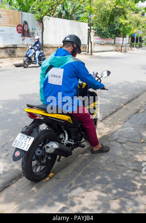 Mitfahrzentrale Uber Motorradfahrer auf seinem Motorrad in Ho Chi Minh City, Vietnam. Stockfoto