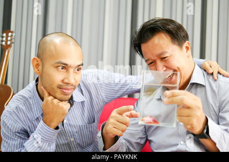 Zwei asiatische Jungs sehen Betta Fisch im Glas und sehr glücklich Stockfoto