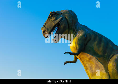 Abgenutzte Modell des T-Rex gegen den blauen Himmel Stockfoto