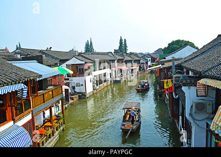 Shanghai Zhujiajiao Wasser Stadt, China, Juli 2015. Zwei Boote mit Schiffer und passieren die Touristen die Häuser auf dem Wasser Stadt Kanal in einem sonnigen Tag. Stockfoto
