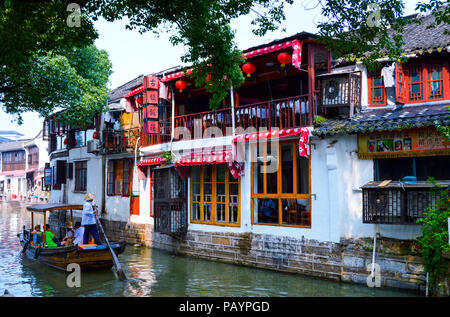 Shanghai Zhujiajiao, China, Juli 2015. Ein Boot mit Bootsmann und Touristen auf dem baumbestandenen Kanal im Wasser Zhujiajiao Stadt. Stockfoto