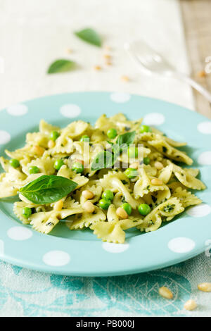 Pasta mit Pesto, grüne Erbsen und Basilikum auf einem Holztisch. Rustikaler Stil, selektiven Fokus. Stockfoto