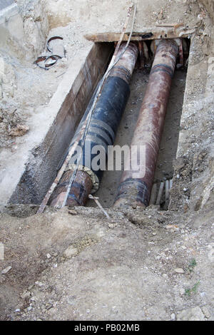 Reparatur der Heizung Rohre in einer Tiefe von ausgehobenen Grabens Stockfoto