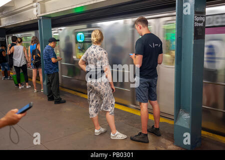 Wochenende der u-bahn Fahrer warten auf einen Zug auf der Spring Street Station in der New Yorker U-Bahn am Samstag, 14. Juli 2018. (Â© Richard B. Levine) Stockfoto