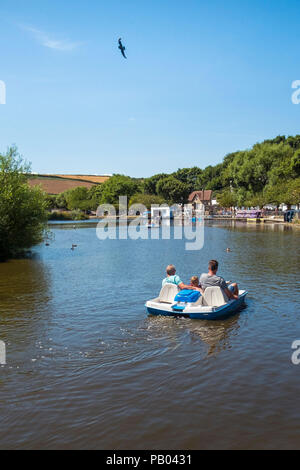 Urlauber, die in einem gemieteten Tretboot auf trenance See zum Bootfahren in Newquay Cornwall. Stockfoto