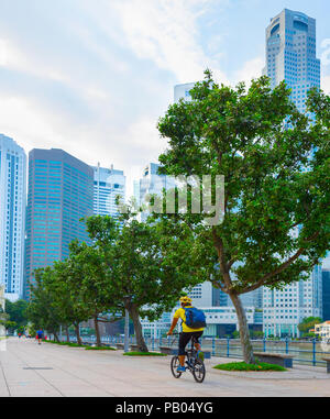 Unbekannter Mann reiten Fahrrad auf dem Singapore River Embankment Stockfoto