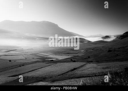 Anzeigen von Castelluccio Di Norcia (Umbrien) in der Dämmerung, bei Nebel, große Wiesen und völlig leeren Himmel Stockfoto
