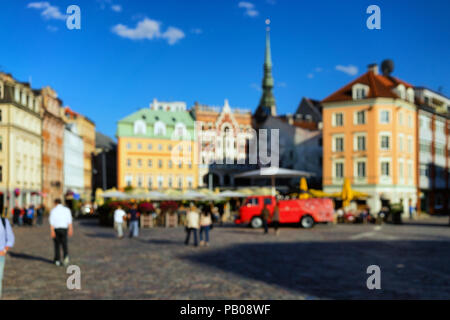 Menschen in ein Café im Freien sitzen an einem sonnigen Tag auf dem Platz in der Altstadt von Riga blurry Feder Stockfoto