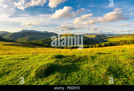 Wunderschöne Landschaft am Abend. flauschige Wolken über die Berge in der Ferne. Ruhige und entspannende Szene vor Sonnenuntergang Stockfoto