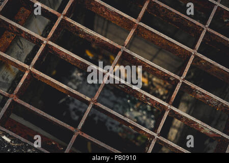 Blick von oben auf die Alten und rostiges Metall auf der Straße Ablassschlauch abgedeckt. Rost Metall Textur Hintergrund. Salz Wasser beschleunigt Rost. Oberfläche aus Metall in Bau Stockfoto