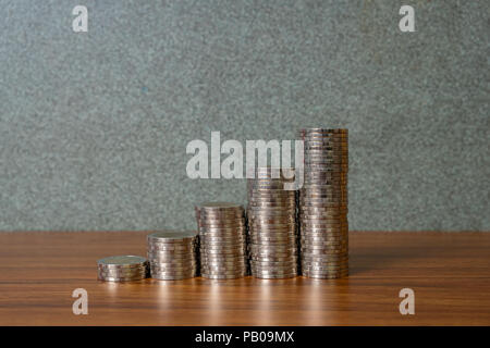 Einsparungen, Erhöhung der Spalten von Goldmünzen, Stapel von Goldmünzen als Grafik auf Schreibtisch, Business Banking Idee. Stockfoto