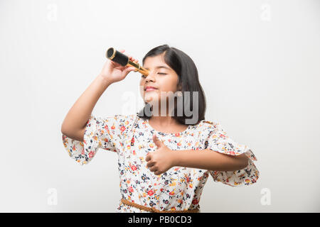 Nette kleine indische / asiatische Mädchen mit Stretch-Teleskop und Blick in den Himmel, wollen ein Wissenschaftler sein. Isoliert stehend über weißem oder grünem Chalkbo Stockfoto