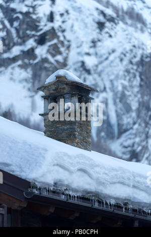 Ferienhaus Schornstein auf dem Dach mit Schnee bedeckt Stockfoto