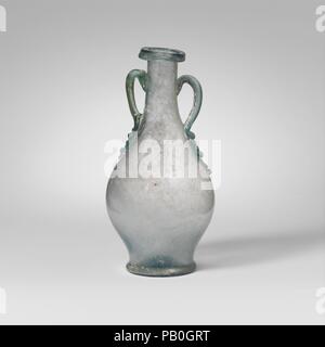 Glas zwei- Flasche (AMPHORA). Kultur: Roman. Abmessungen: 4 15/16 x 2 7/16 in. (12,6 × 6,2 cm) Durchm. Von rim: 15/16 in. (2,4 cm) Durchm. Der Fuß: 1 5/8 in. (4.1 cm). Datum: 1.-2. Jh. N.CHR.. Translucent Hellblau, mit der gleichen Farbe Griffe. Collared rim, aslant an Hals, Ausgeklappt, nach unten und oben, die Lippe auf dem äußeren Rand des abfackeln Mund; zylindrische Hals Erweiterung nach unten unmerklich mit eiförmigen Körper zu verbinden, die dann die Kurven etwas niedrigen Basis ring; konkaver Boden mit zentralen pontil Narbe; Stange Griffe angewendet, so lange nach unten verjüngend Wanderwege Seiten und den unteren Teil des Halses, dann gezeichnet Stockfoto