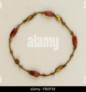 Armband mit Perlen. Abmessungen: Durchm. Ca. 4 cm (1 9/16 in.). Dynastie: Späte Dynastie 21. Datum: Ca. 1000-945 v. Chr.. Identisch mit einer Armbänder gefunden um den rechten Henettawy's Handgelenk (25.3.190 c), so ist diese Länge von 2-ply leinene Schnur wurde in regelmäßigen Abständen geknotet und mit vier Karneol und drei Gold barrel Perlen, dann um ihr linkes Handgelenk gebunden. Der Schmuck auf der Mumie war höchstwahrscheinlich verschlissen durch Henettawy während ihres Lebens. Museum: Metropolitan Museum of Art, New York, USA. Stockfoto