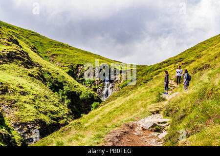 Wanderer angehalten auf dem Fußweg Grau Mares Schwanz Wasserfall der Moffat Hügel, Dumfries and Galloway, Schottland, UK zu bewundern. Stockfoto