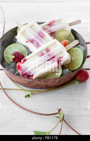 Eis am Stiel mit Erdbeeren und Kalk Stockfoto