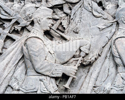 Ein Detail des Schottischen American Memorial in die Princes Street Gardens und Edinburgh, Schottland, Vereinigten Königreich, die einen KILTED Tasche Piper. Stockfoto