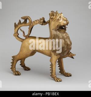 Aquamanile in Form eines Löwen. Kultur: Deutsch. Abmessungen: 12 9/16 x 4 5/8 x 12 1/2 in., 11.76 lb. (31,9 x 11,8 x 31,8 cm, 5336 g) Dicke: 1/16-1/8" in. (0.16-0,35 cm). Datum: Ca. 1400. Diese aufwändige Wasser Schiff wurde für Vorrichtungen zum Händewaschen vorgesehen. Eine Spezialität der Metallarbeiter in den deutschsprachigen Ländern seit Jahrhunderten - vom zwölften bis zum Fünfzehnten - Sie werden als aquamanilia, von den lateinischen Wörtern für Wasser (Aqua) und Hand (MANUS). Breite-chested, Mähne hervorstehende, und den Mund öffnen, der Löwe ist unverhohlen Stolz und wachsam. Diese außergewöhnliche König der Tiere zu erstellen, die der Künstler zuerst einen r Stockfoto