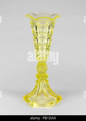 Vase. Kultur: American. Abmessungen: H.11 cm. (29,2 cm). Schöpfer: Boston & Sandwich Glass Company (American, 1825-1888, Sandwich, Massachusetts). Datum: 1835-45. Die Nachfrage nach aufwendigen, aber preiswerte Geschirr, Gewächshäusern produziert eine große Tabelle der Dienste Alle in einem Muster. In der Ausstellung des Industrie aller Nationen in der New Yorker Crystal Palace 1853, zum Beispiel, die New England Glass Company 130 Stücke von einem Design ausgestellt", bestehend aus Schalen, Bechern, Champagner, Weine, und Gelee Brille.". Museum: Metropolitan Museum of Art, New York, USA. Stockfoto