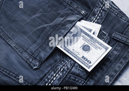 Banknoten eines hundert Dollar mit einem Porträt von Franklin peep aus der Tasche der Jeans Hose. Geld in der Tasche, Geld sparen, pocket expens Stockfoto