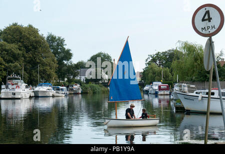 Mann und der Junge in einem Segelboot auf dem Fluss Waveney, Beccles, Suffolk, Großbritannien Stockfoto