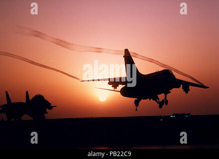 A-7E Corsair II Sonnenuntergang. Eine A-7E Corsair II Flugzeug landet auf dem Flugdeck der Atom-Flugzeugträger USS CARL VINSON (CVN-70) bei Sonnenuntergang. Stockfoto