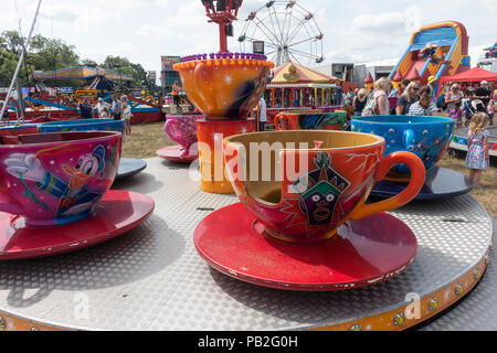 Bunte Tasse und Untertasse Kreisverkehr Messegelände fahren für Kinder an einem sonnigen Tag in der Landwirtschaft zeigen Nantwich Cheshire England Vereinigtes Königreich Großbritannien Stockfoto