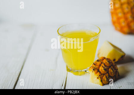 Ananas Saft in ein Glas Flasche weiß Holz Hintergrund Stockfoto