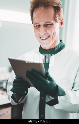 Zufrieden lächelnd Biotechnologe lesen Wissenschaft Nachrichten Stockfoto