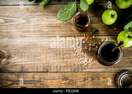 Home Warme dunkle gesalzen classic Karamell-sauce, mit grünen Äpfeln, Holz- und dunkelblauen Hintergrund, Stockfoto