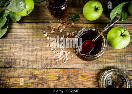 Home Warme dunkle gesalzen classic Karamell-sauce, mit grünen Äpfeln, Holz- und dunkelblauen Hintergrund, Stockfoto