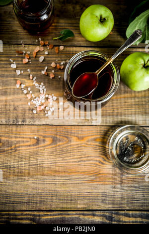 Home Warme dunkle gesalzen classic Karamell-sauce, mit grünen Äpfeln, Holz- und dunkelblauen Hintergrund, Stockfoto