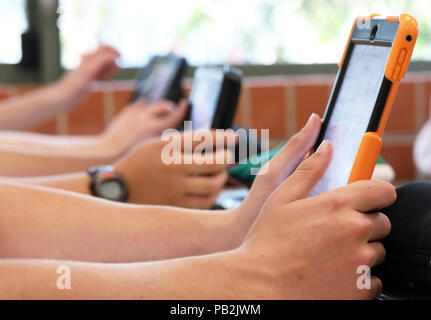 Schülerinnen und Schüler arbeiten mit einem ipad tablet style Electronic computer Gerät. moderne Pädagogik und Unterricht Lernen in Bildung pädagogische Stockfoto