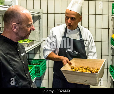 Küchenchef Stefan Lüse vom Hotel Lenkerhof demonstriert dem Reporter Georg Berg die La Bonnotte Potatoes, Lenk, Schweiz Stockfoto