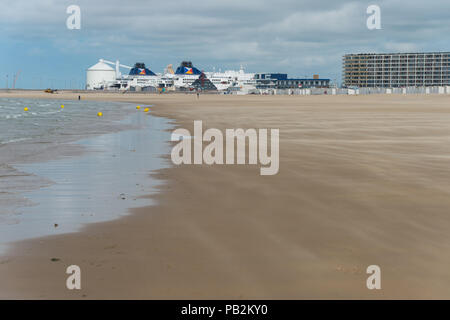 Calais, Frankreich - 19. Juni 2018: Strand bei Ebbe im Sommer und Fähre im Hafen angedockt. Stockfoto