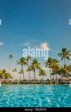 Pool mit Palmen in der Nähe des Ozeans bei einem schönen Sonnenuntergang in Praia do Forte, Bahia, Brasilien. Stockfoto