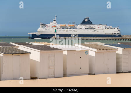 Calais, Frankreich - 19. Juni 2018: Beach Cabins und DFDS Cross Channel Fähre auf dem Weg nach Dover, Großbritannien. Stockfoto