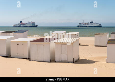 Calais, Frankreich - 19. Juni 2018: Beach Cabins und DFDS/P&O Cross Channel Fähren. Stockfoto